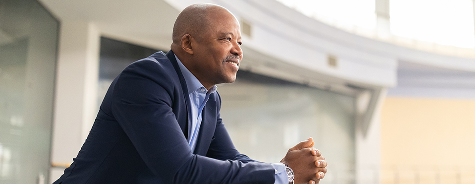 diverse leader looking over a balcony as an image of self-reflection in leadership