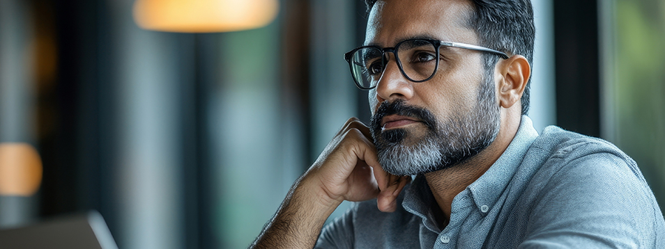 Man in thought in front of his computer as an image of leadership decision making