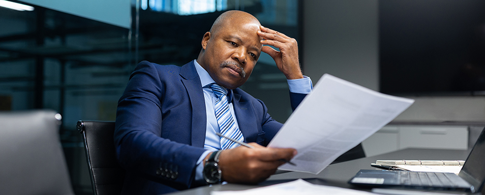A businessman decision making under pressure at his desk with papers