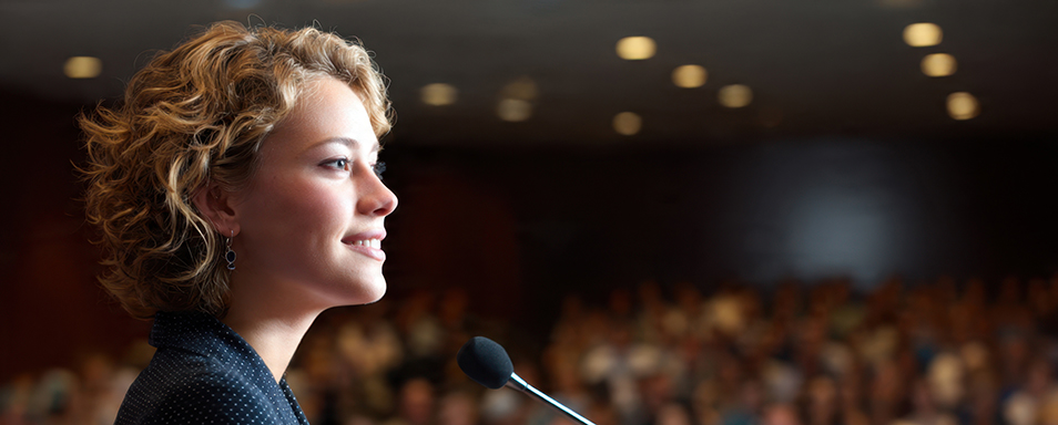 A female leader showing quiet confidence leadership as she steps up to the podium