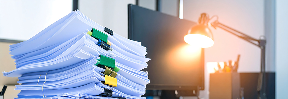 papers piled up as an image of a leadershp bottleneck